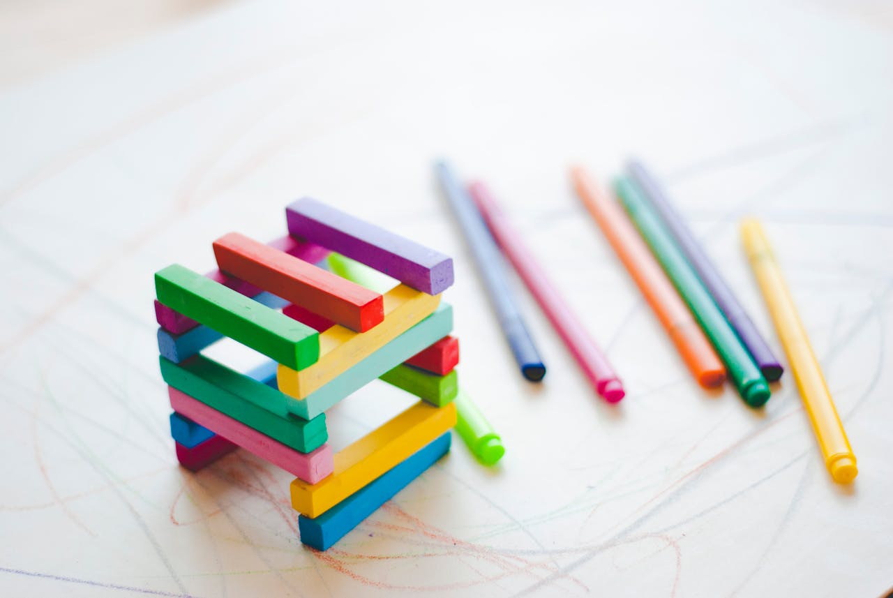 Brightly colored wooden sticks arranged on a white background, perfect for creativity.